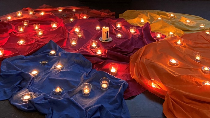 Farbenfrohe Decken mit Kerzen im Raum, großes Fenster mit Aussicht