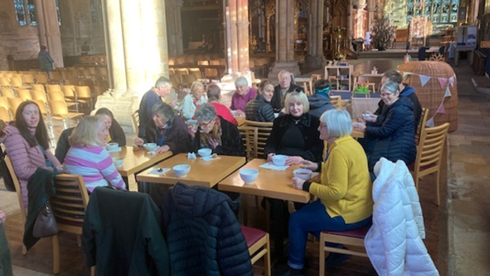 Group of people sitting at tables in a cafe.