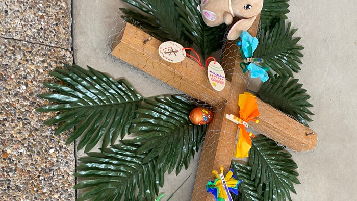 En palmekrans med et kryds og diverse smykker.