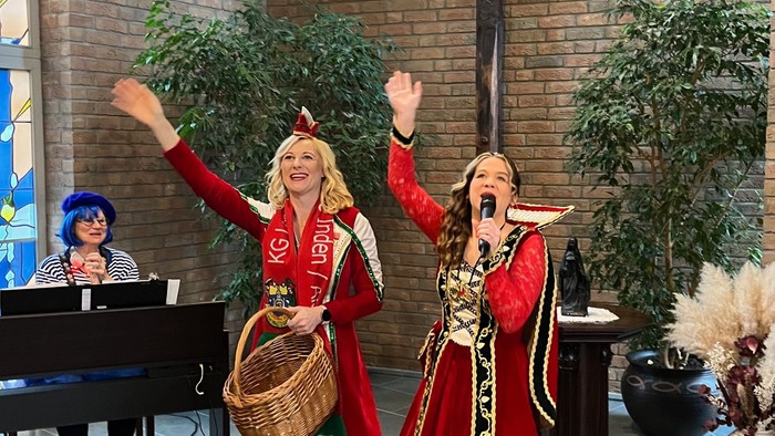 Zwei Frauen in historischen Kostümen vor Kreuz und Klavier