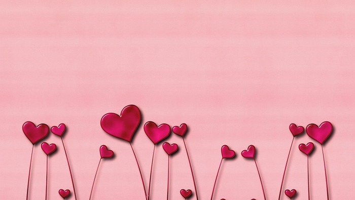 Røde hjerte-formede balloner på stænger foran rosa baggrund