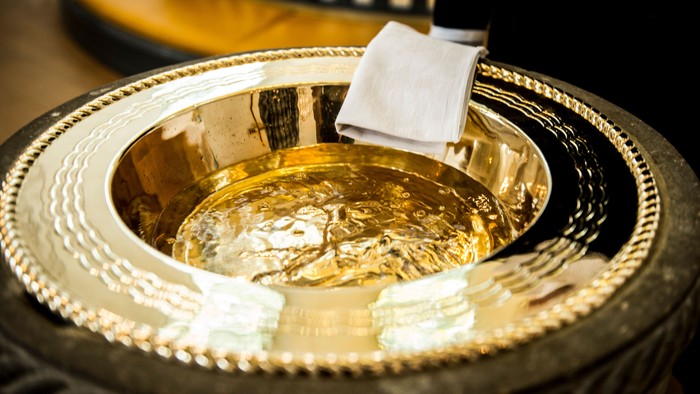 En smuk og poleret sølvbåde med en hvid klæde og en skøn skål.