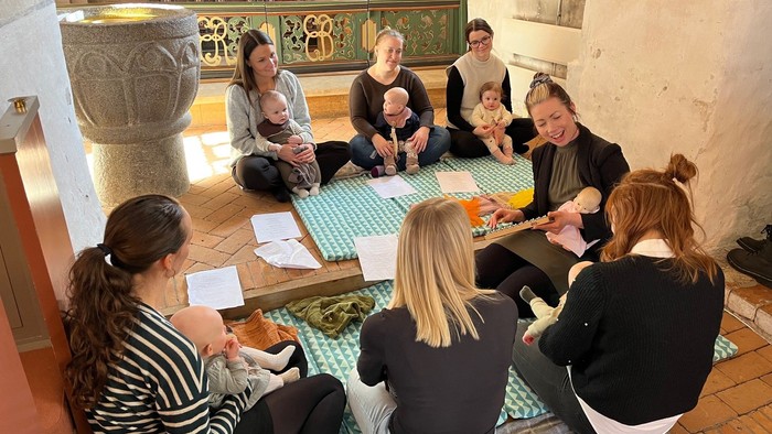 Forældre med deres babyer nyder musik på kirkegulvet