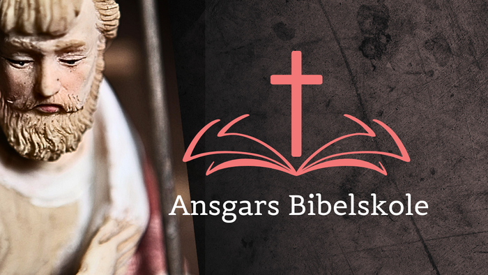 En statue af en mand med skæg og en bog med korset og teksten