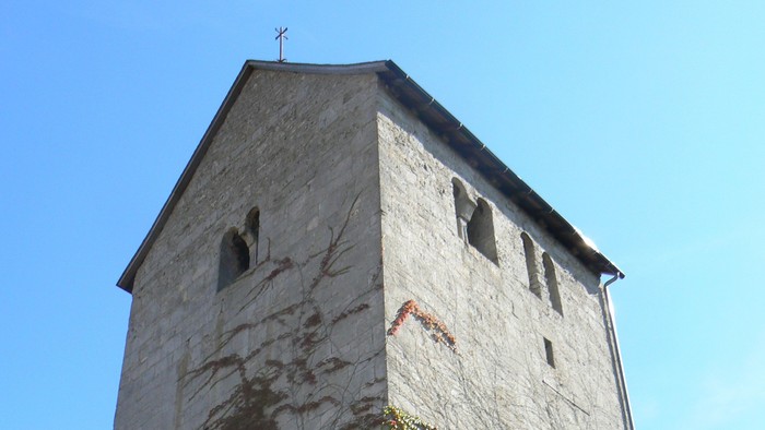 Hoher Steinturm mit Efeu, der daran wächst.