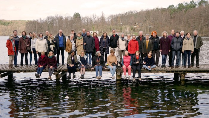 Eine Gruppe von Menschen posiert auf einem Steg über einem Gewässer