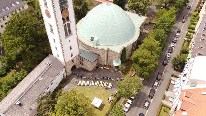 Bei einem Gemeindefest hat eine Menschenkette von über 200 Personen die Kreuzkirche umarmt. Das Foto wurde mit einer Drohne aufgenommen.