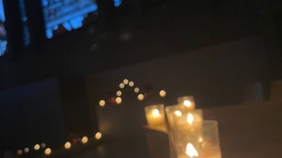 Kleine Kerzen auf einem Tisch vor einem Fernseher