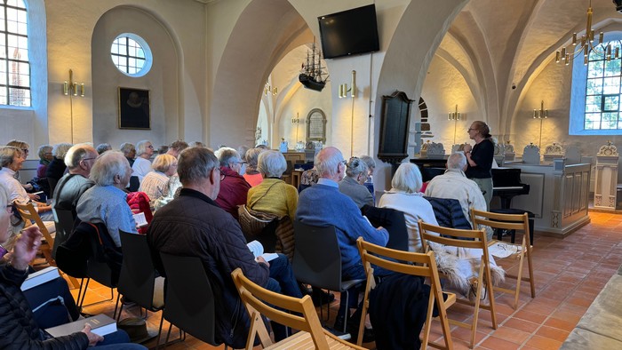 En gruppe mennesker deltager i en foredrag i en kirke.