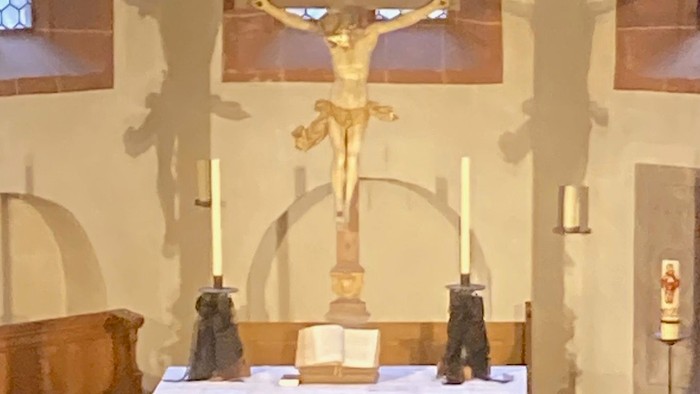 Der Altar in einer Kirche mit Kruzifix und Kerzenhaltern
