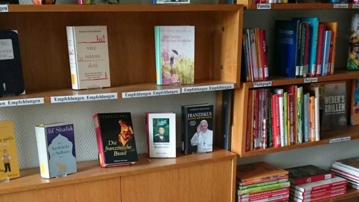 Kleiner Tisch mit zwei Stühlen vor Bücherregalen