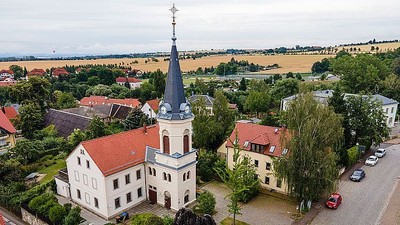 Kirchliches Gebäude mit hohem Turm in ländlicher Umgebung