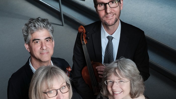 Fire musikerer med strengeinstrumenter.