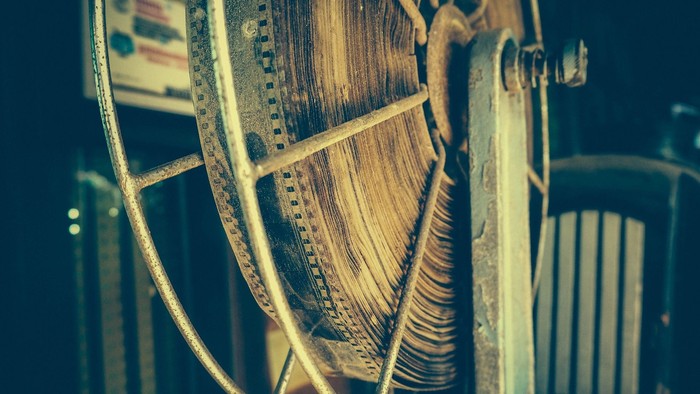 Ein altes, großes Zahnrad mit vielen Zähnen und Metallstangen.