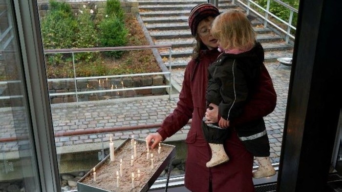 En kvinde og et barn ser ud af et vindue.