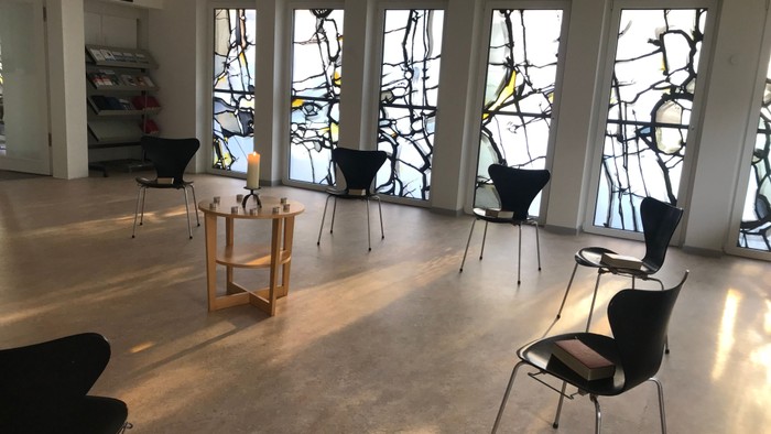 Ein moderner Raum mit großen Fenstern und schwarzen Stühlen