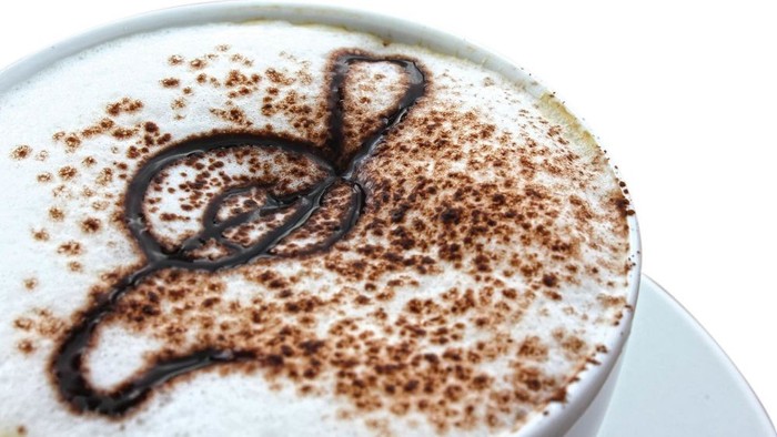 Milchkaffee mit einem Hauch von Kakao und darauf mit Vanille ein Violinschlüssel gemalt