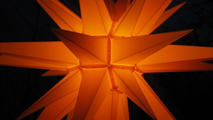 Ein leuchtender orangefarbener Stern vor dunklem Hintergrund