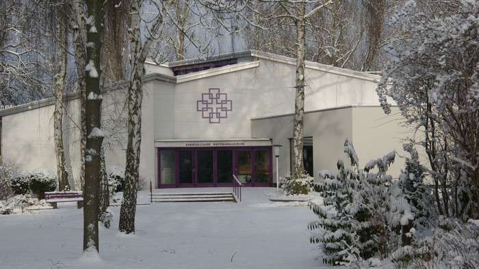 Schneebedecktes Gebäude mit Weihnachtsbaum und Schild