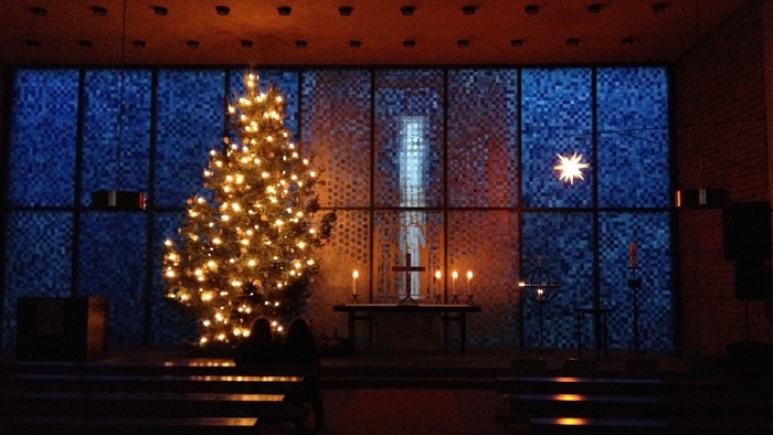Weihnachtsbaum in der Kirche vor Fenster mit Kerzen