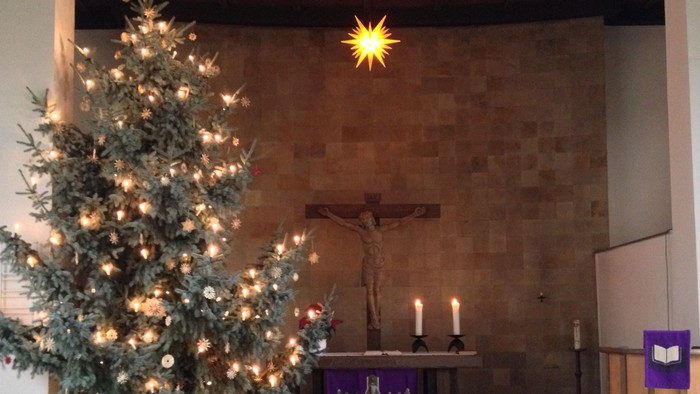 Weihnachtsbaum in der Kirche vor Altar und Kruzifix
