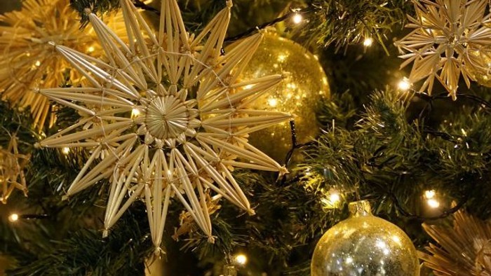 Ein Weihnachtsbaum mit goldenen Ornamenten und Lichtern