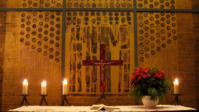 Altar mit Kreuz und Kerzen in Kirchenraum
