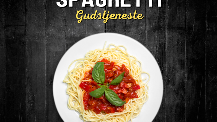 En ret spaghetti med tomat sauce og basilika på en hvid tælle.