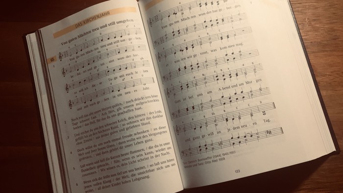 Offenes Buch mit Noten und Text auf einem Holztisch