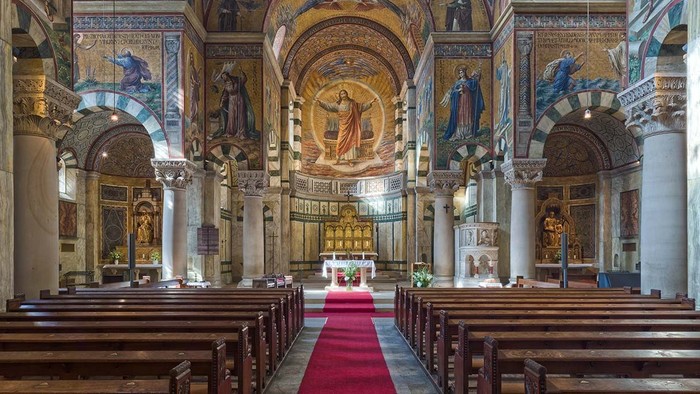 Innenraum einer prächtigen Kirche mit Säulen, Altarraum und religiösen Kunstwerken