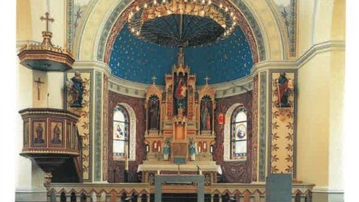 Innenraum einer Kirche mit Altar und Kirchenbänken