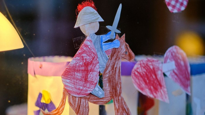 Ein Martin auf dem Pferd, ausgeschnitten aus Papier - im Hintergrund leuchtende Laternen