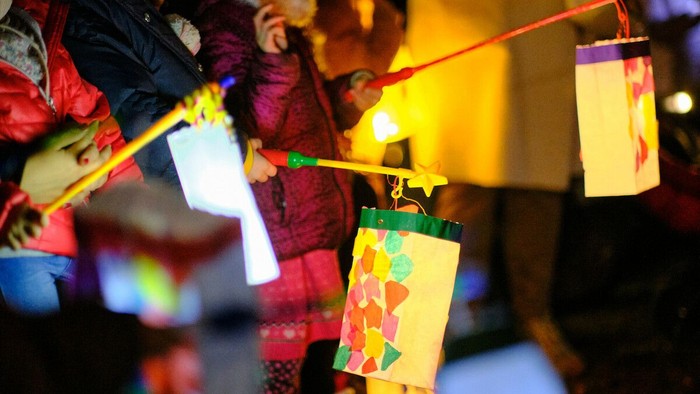 Kinderhände halten selbstgebastelte leuchtende Laternen