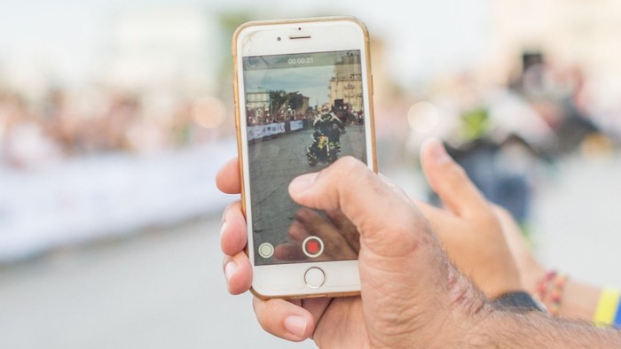 Hand hält Smartphone mit Videoaufnahme von Konzert