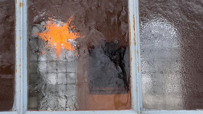 Ein Fenster mit einem sternförmigen Loch und einer zerbrochenen Scheibe.