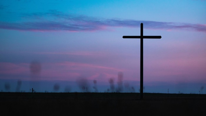 Silhouette of a cross against a colorful sky