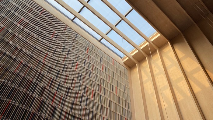 Moderne Fassade mit vertikalen Linien und Glasdach.