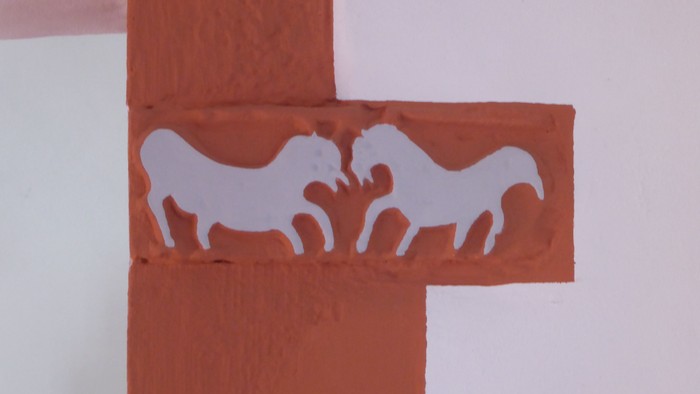 Zwei weiße Pferde auf rotem Hintergrund, umrahmt von einem weißen Kreuz