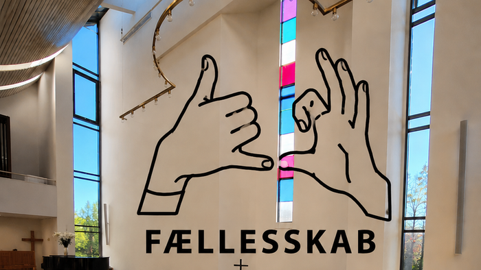 Moderne kirkeinteriør med et indbydende skilt 