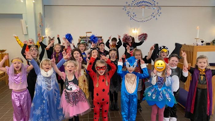 Børn i festlige kostumer samlet i kirke.