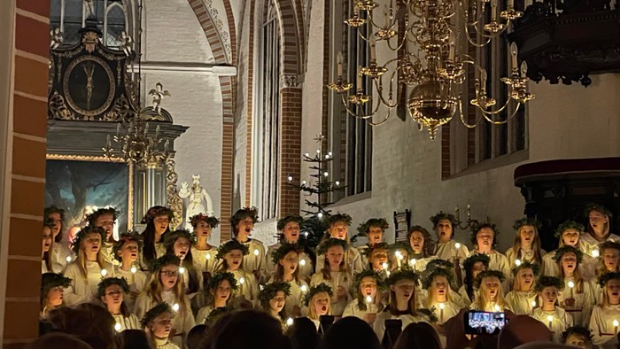 En kirke med en stor kor, der synger med lysede lys.
