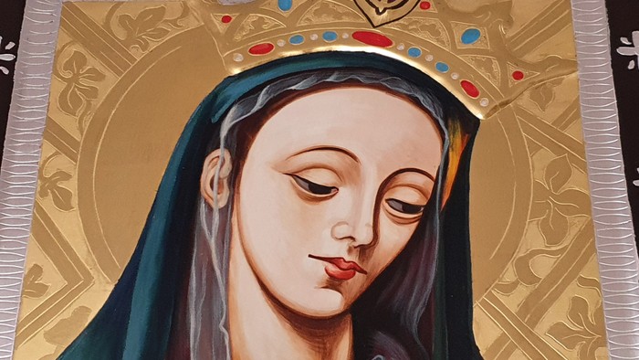Das Bild zeigt eine Darstellung der Jungfrau Maria mit Krone und blauem Umhang.