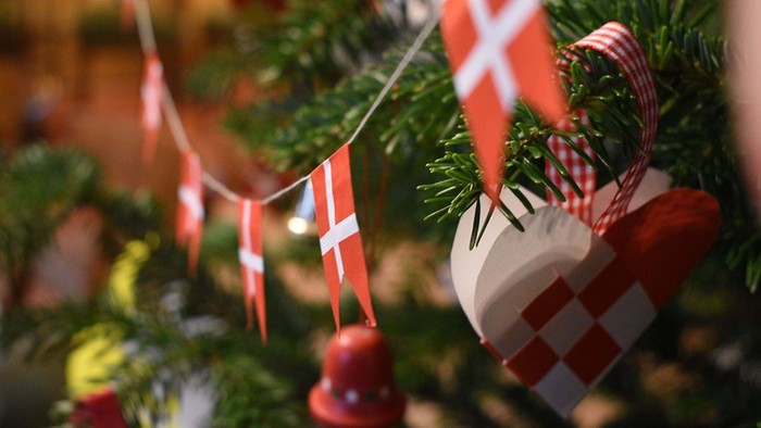 En juletree dekoreret med danske flag og røde luehatter