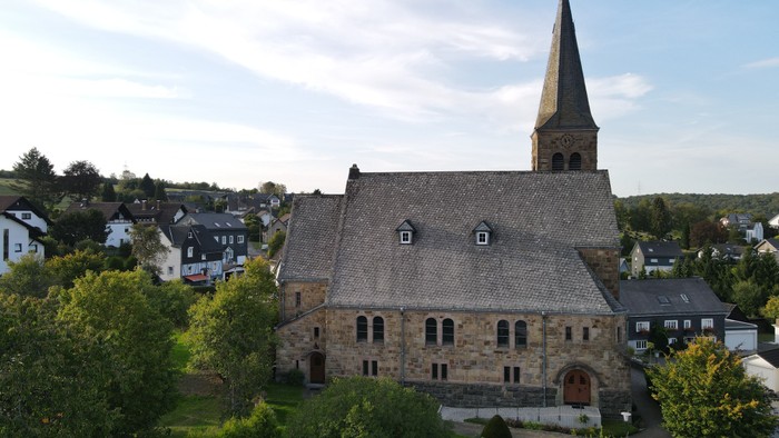Kirchengebäude mit hohem Turm in kleinem Ort