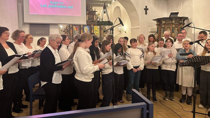 En kor sang i kirke med projektor og noter