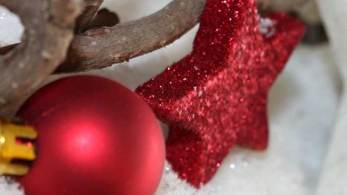 Rød julepynt og stjernedekoration på sne.