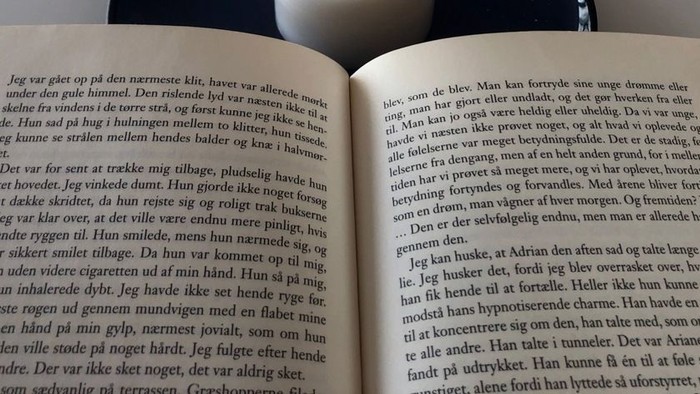 En åben bog med tekst på dansk.