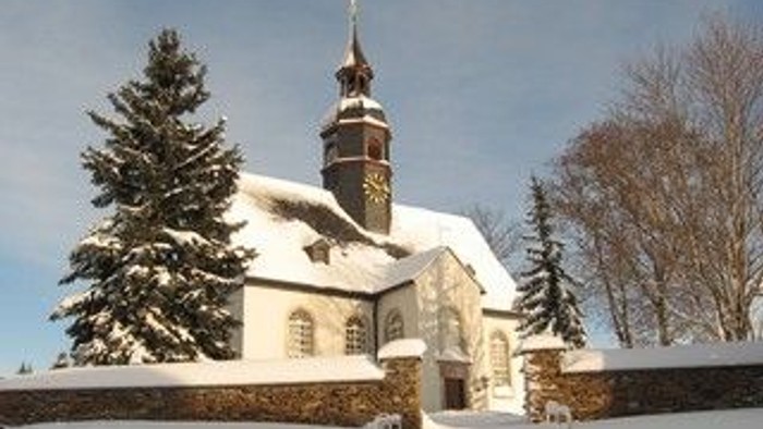 Weiße Kirche im Winter mit Schnee und Bäumen