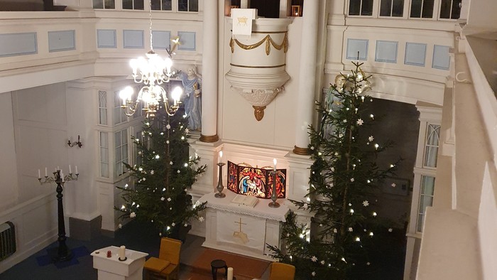 Großer Raum mit zwei Weihnachtsbäumen und grosser Uhr