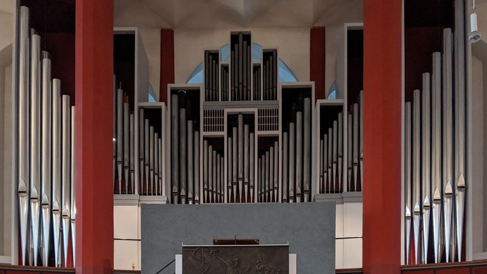 Orgel in Kirche mit farbenfrohem Gehäuse und Relief